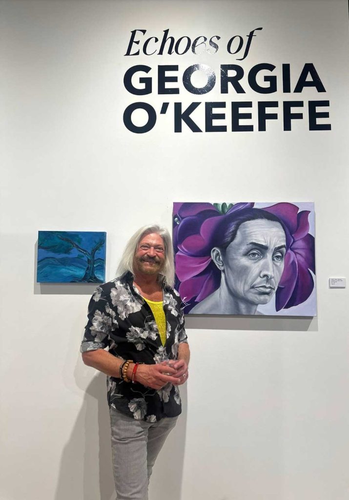 Josef Berliner at his art show in front of his painting in a gallery.